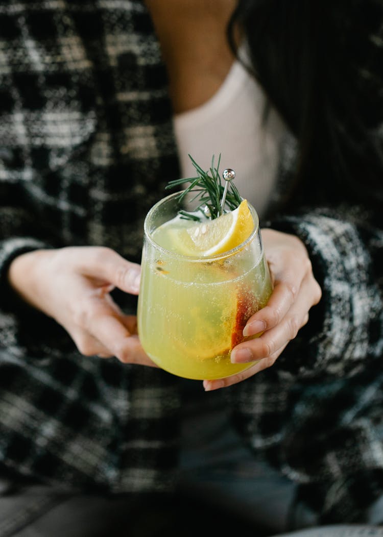 A Person Holding A Cocktail In A Glass