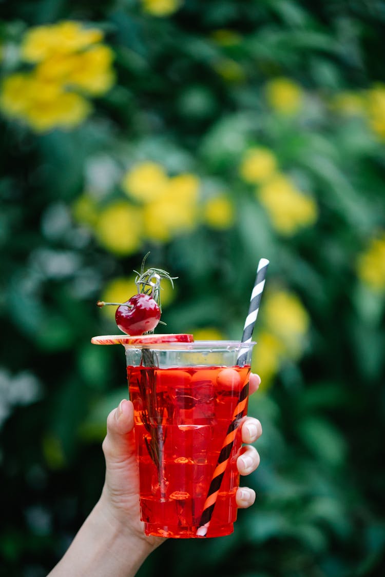 Close-up Holding A Red Drink With A Cherry