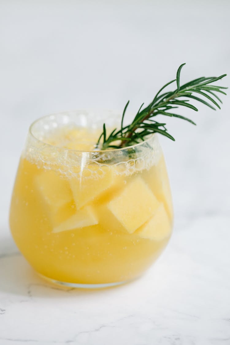 Juice On Glass Cup With Rosemary Garnish