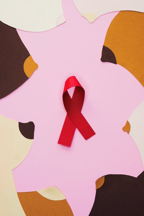 Close-Up Shot of a Red Ribbon on a Pink Surface