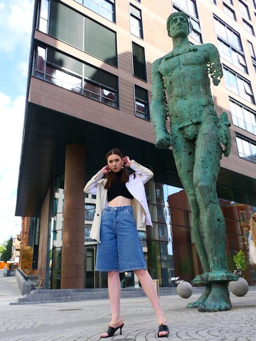 Stylish Woman Standing Beside a Statue