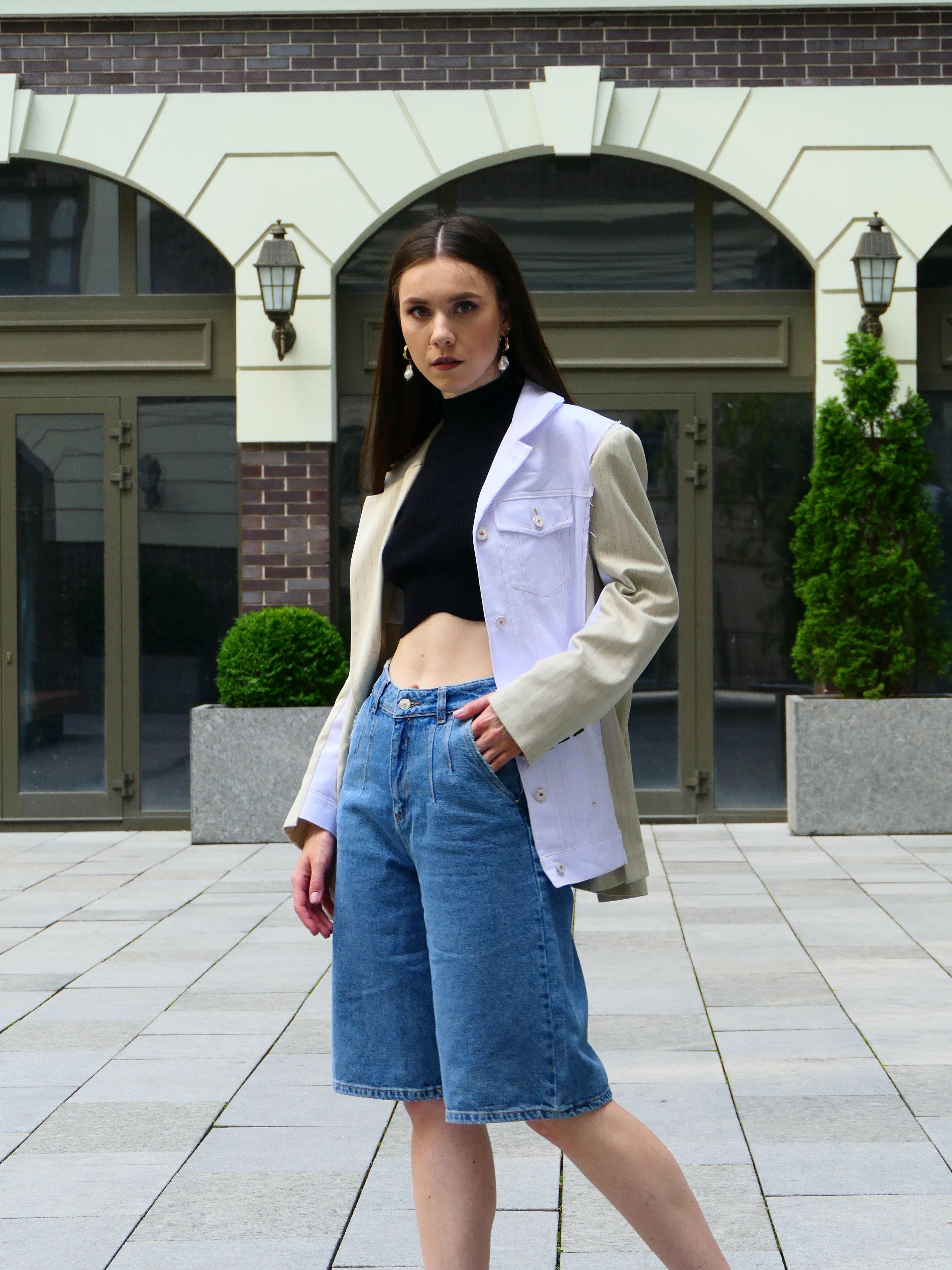 Mulher estilosa posando ao ar livre com um traje moderno, exibindo a moda urbana contemporânea.
