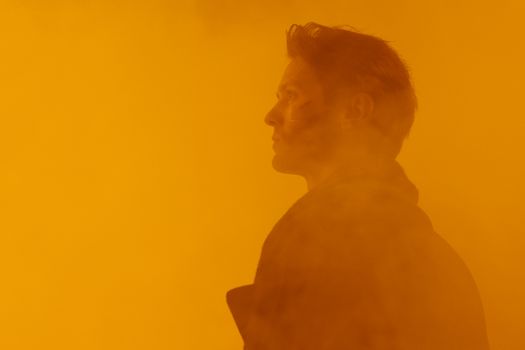 A conceptual close-up portrait of a man in a dystopian, orange-hued setting.