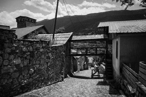 Free Explore a picturesque street in Mestia, Georgia capturing traditional architecture against stunning mountainous backdrops. Stock Photo