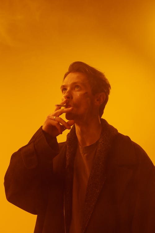 Man in Black Coat Smoking a Cigarette