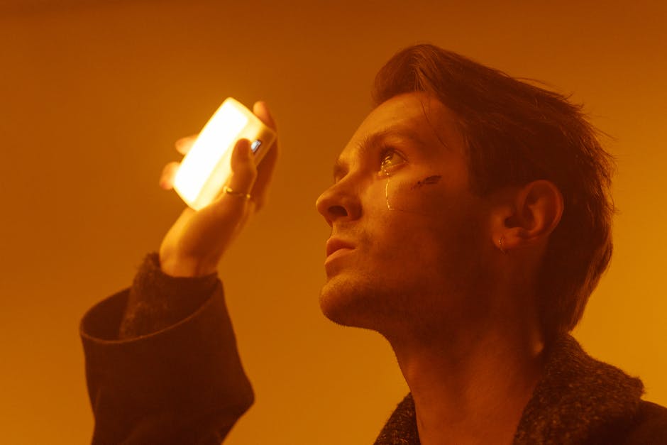 A captivating portrait of a man in warm ambient lighting, holding a light source in his hand.