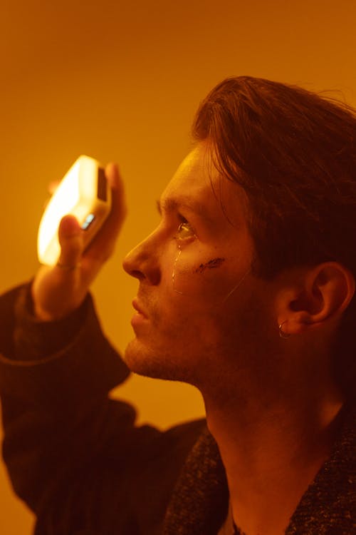 Close-up Photo of Man holding a Portable Light
