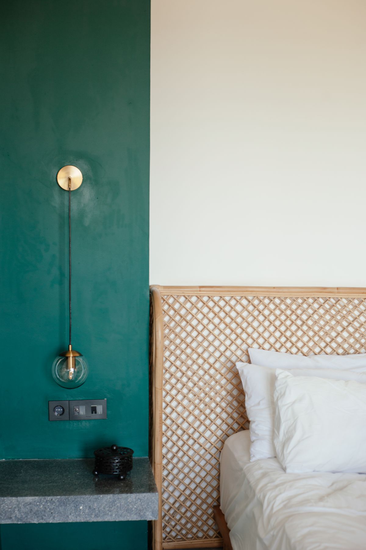 Bedroom with a terracotta painted arch on the wall behind the bed
