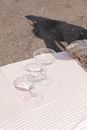 Clear Wine Glass on White and Pink Stripe Textile