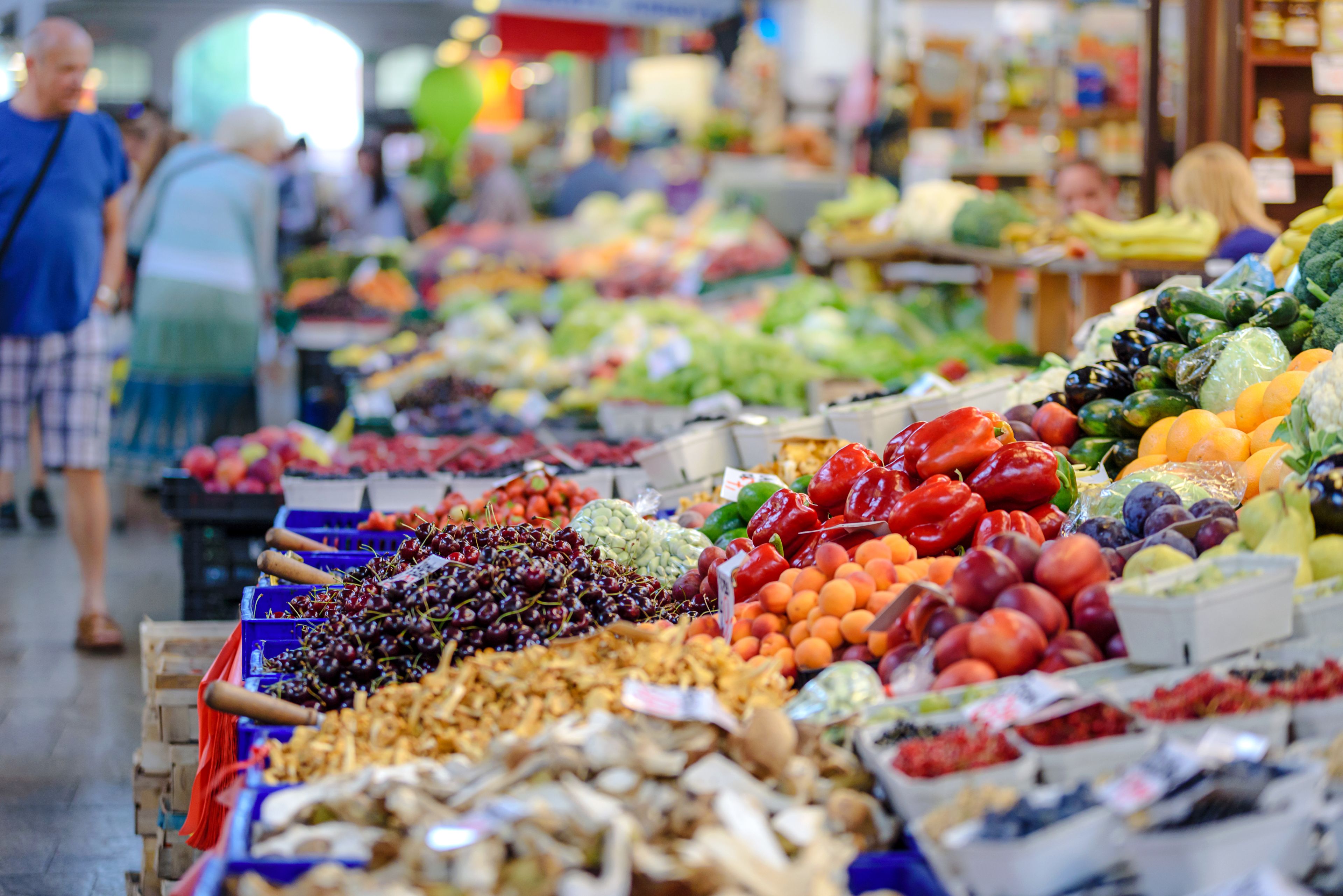 Market stalls piled with fresh produce on a busy morning