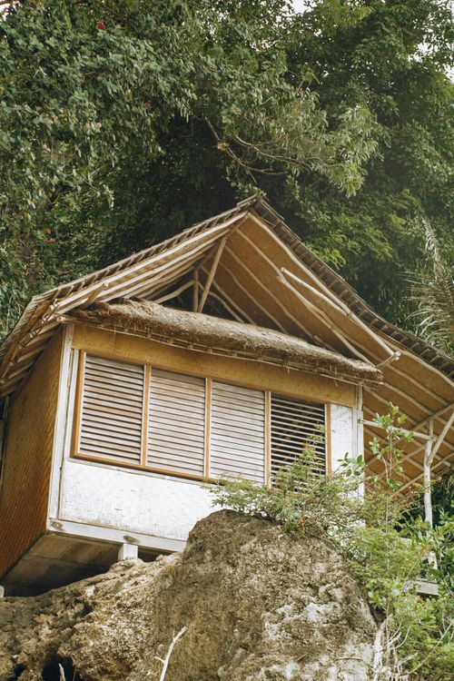 Free A wooden house perched on a cliff with lush greenery, showcasing rustic architecture. Stock Photo