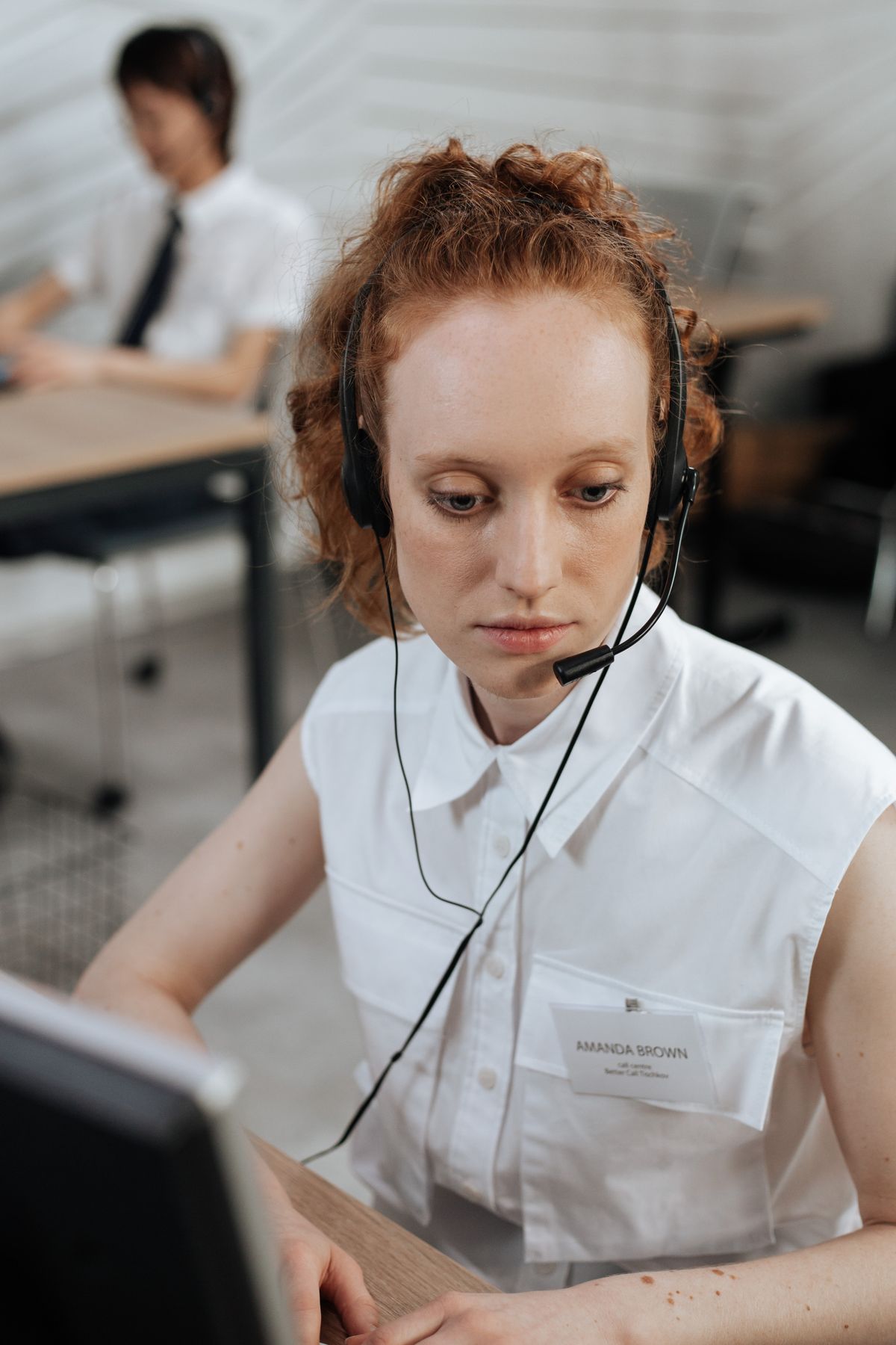 A friendly support adviser wearing a headset while working at a laptop