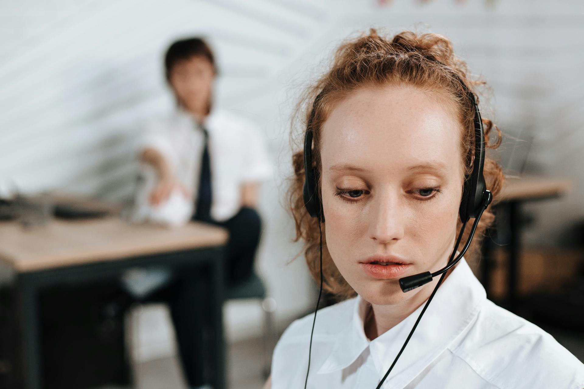 Customer service agent using headset in a modern office environment, focused on her task.