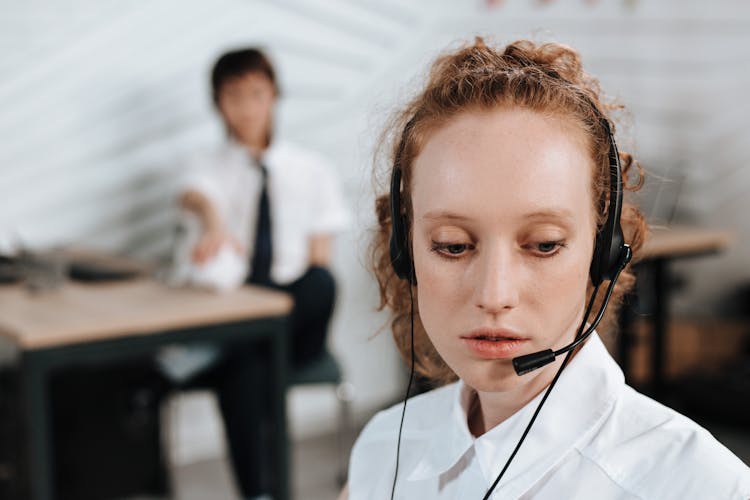 Woman In White Top Wearing A Black Headset