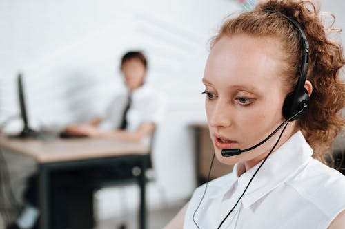 A Woman in White Polo Shirt Wearing a Headset at Work