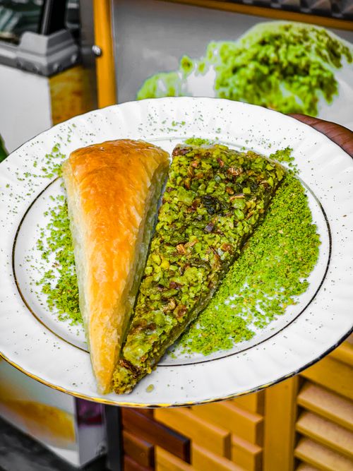 Free Close-up of delicious pistachio baklava on a white plate, perfect for dessert enthusiasts. Stock Photo
