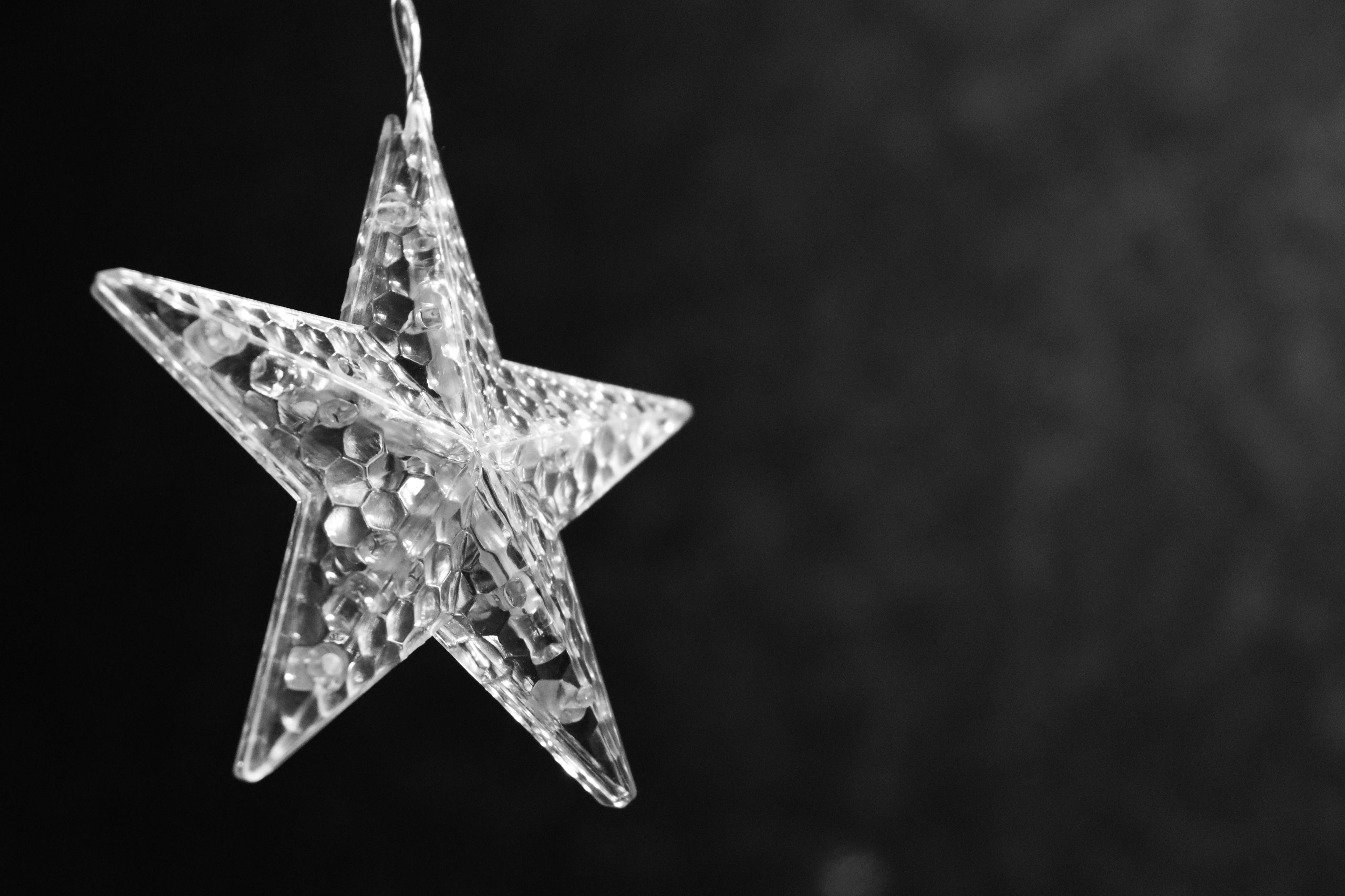 Close-up of a crystal star decoration against a dark background.