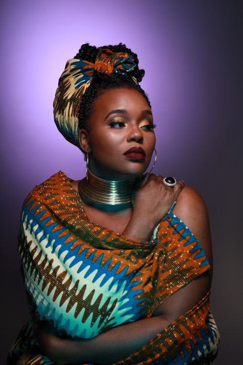Free Striking studio portrait of a woman in colorful printed attire with bold accessories. Stock Photo