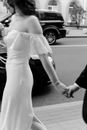 Grayscale Photo of Woman in White Dress Walking on Street