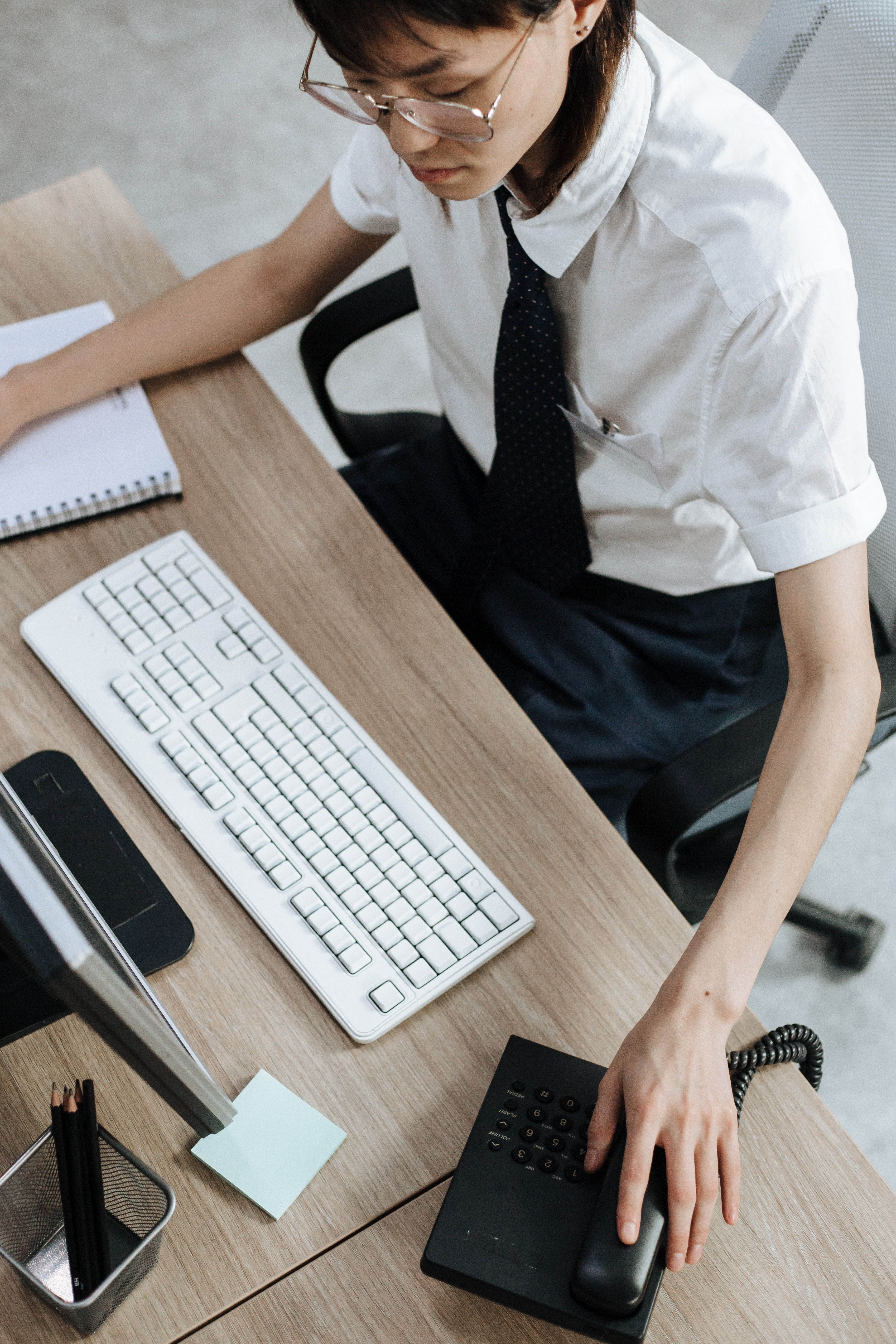A Woman Answering a Call from a Telephone · Free Stock Photo