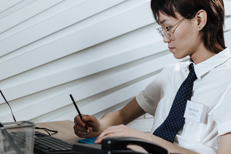 Woman Wearing A Necktie Working On Her Desk