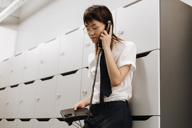 A Man Talking On A Black Telephone