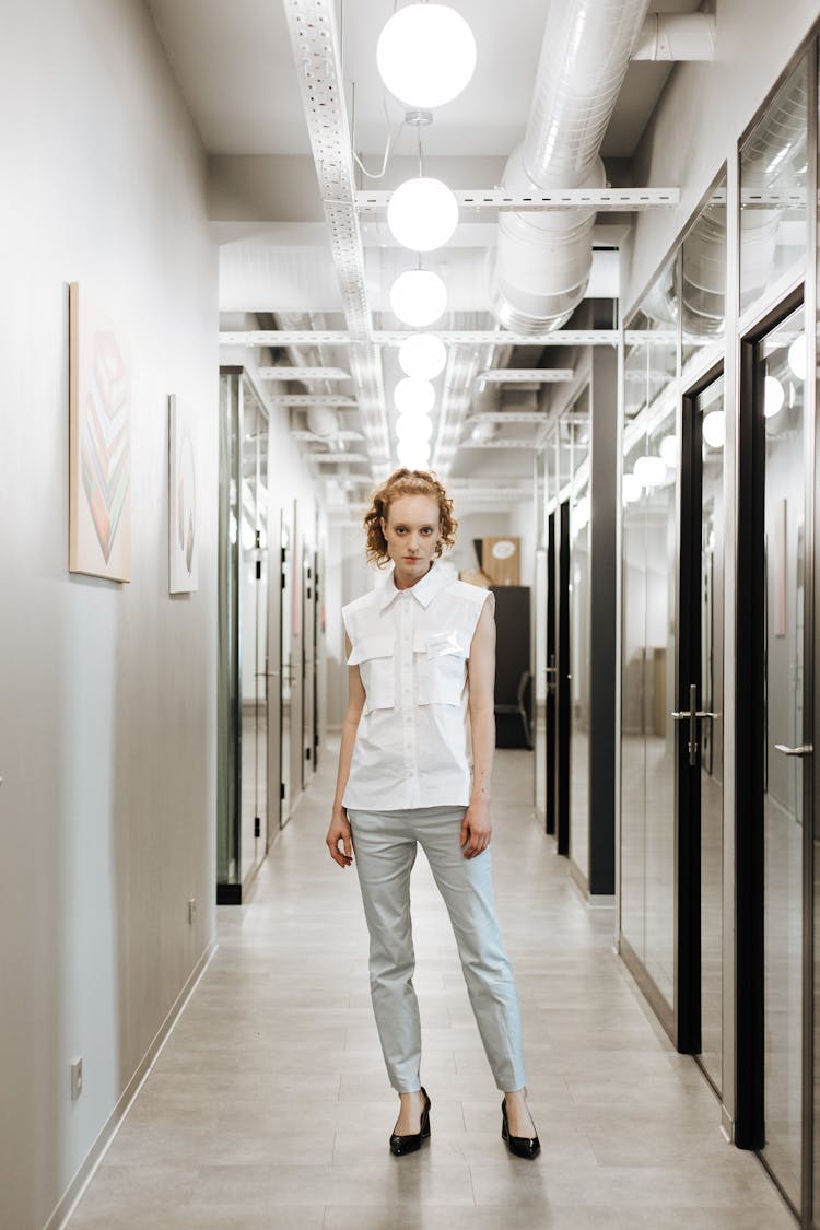 A Woman Standing On An Office Hallway