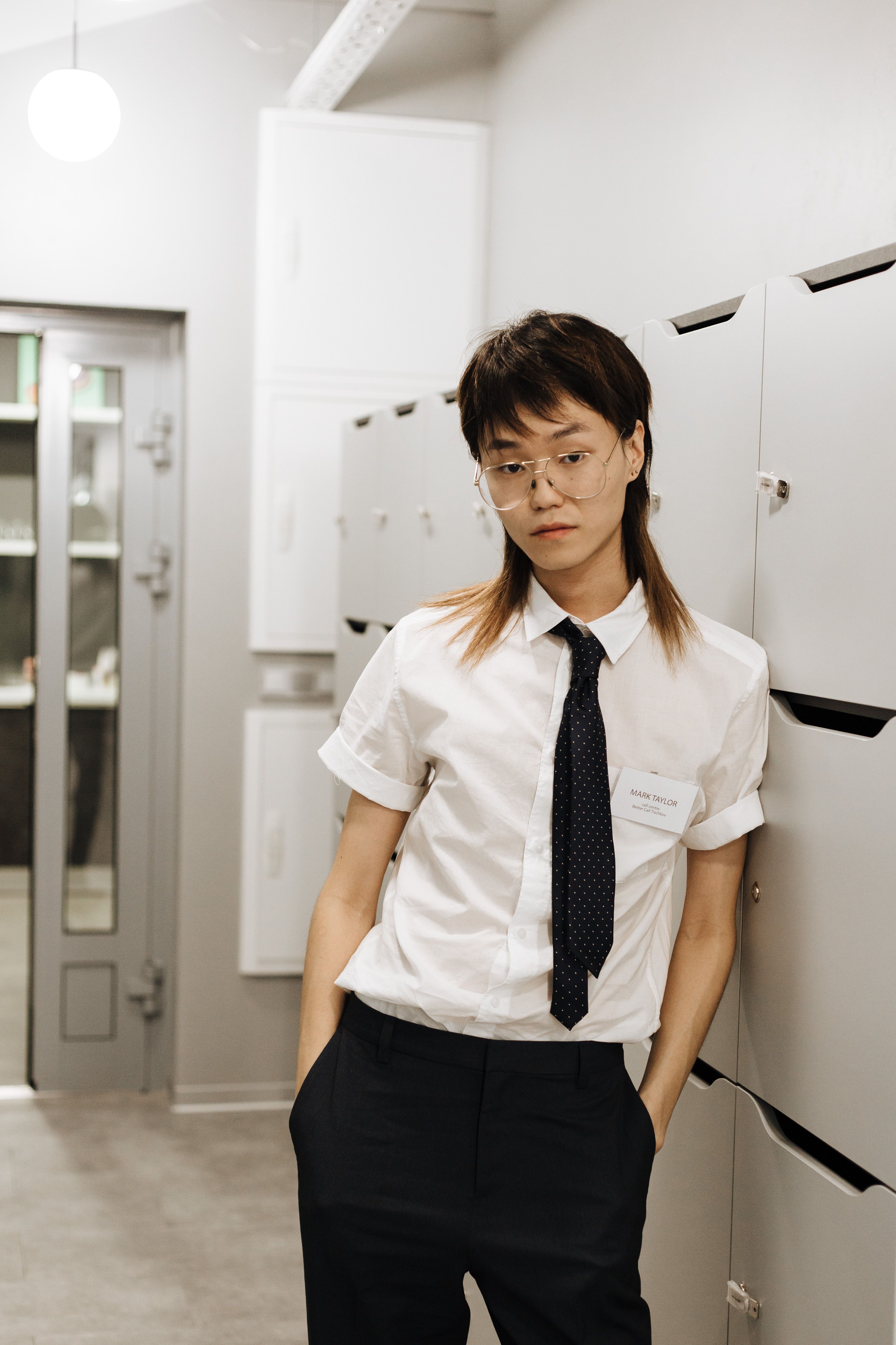 Woman in White Button Up Shirt Leaning Against Locker · Free Stock Photo