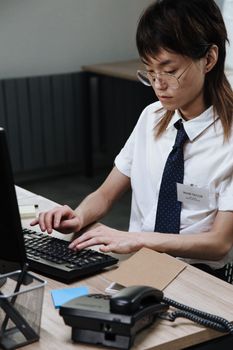 Professional call center agent in office attire working diligently on a computer.
