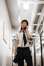 Woman in White Button Up Shirt and Black Pants Standing Near White Wall