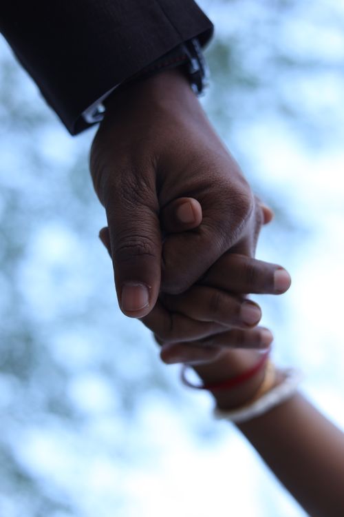 Free Close-up of diverse hands holding in unity with a blurred background, symbolizing connection. Stock Photo