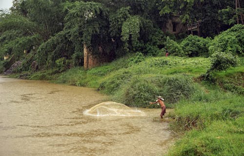 A Fisherman Throwing Fish Net on the Pond