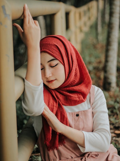 Free Beautiful Woman in a Red Hijab Leaning on a Railing Stock Photo