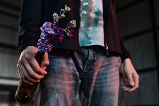 Close-up of a Person Holding a Bottle with Purple Flowers