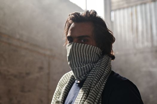A Man Wearing Scarf while Seriously Looking at the Camera