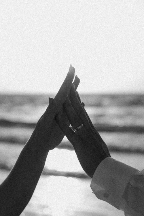 Free Monochrome photo of hands touching affectionately by the ocean. Stock Photo