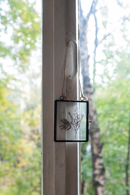 Hanging Glass Frame with Dried Flower on the Handle of the Glass Window