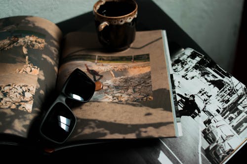 Free Stylish sunglasses placed on opened magazines Stock Photo