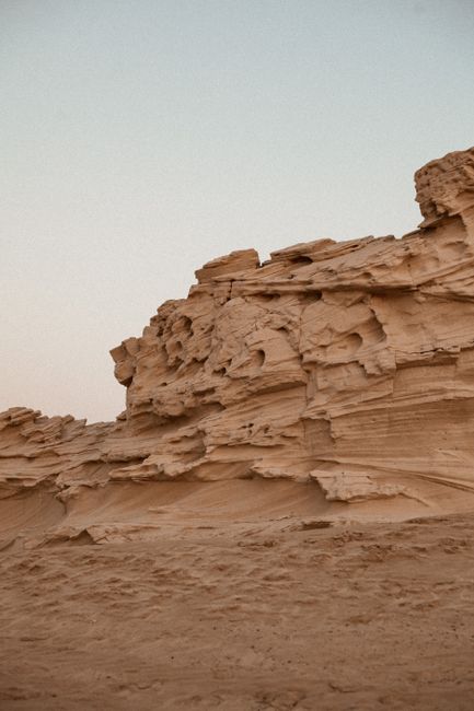 Stunning sandstone rock formations in a tranquil desert landscape under a clear sky.