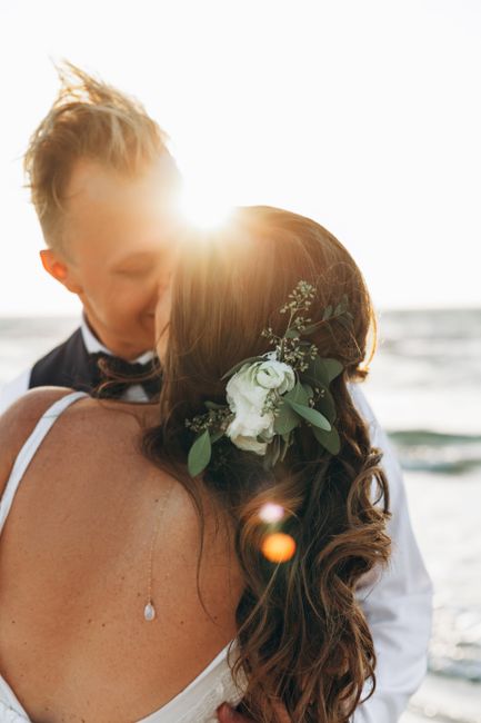 A romantic moment shared by a couple at a beach wedding during sunset.