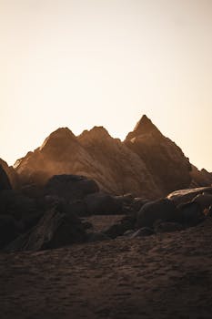 A captivating view of rock formations silhouetted against a golden sky during sunset.