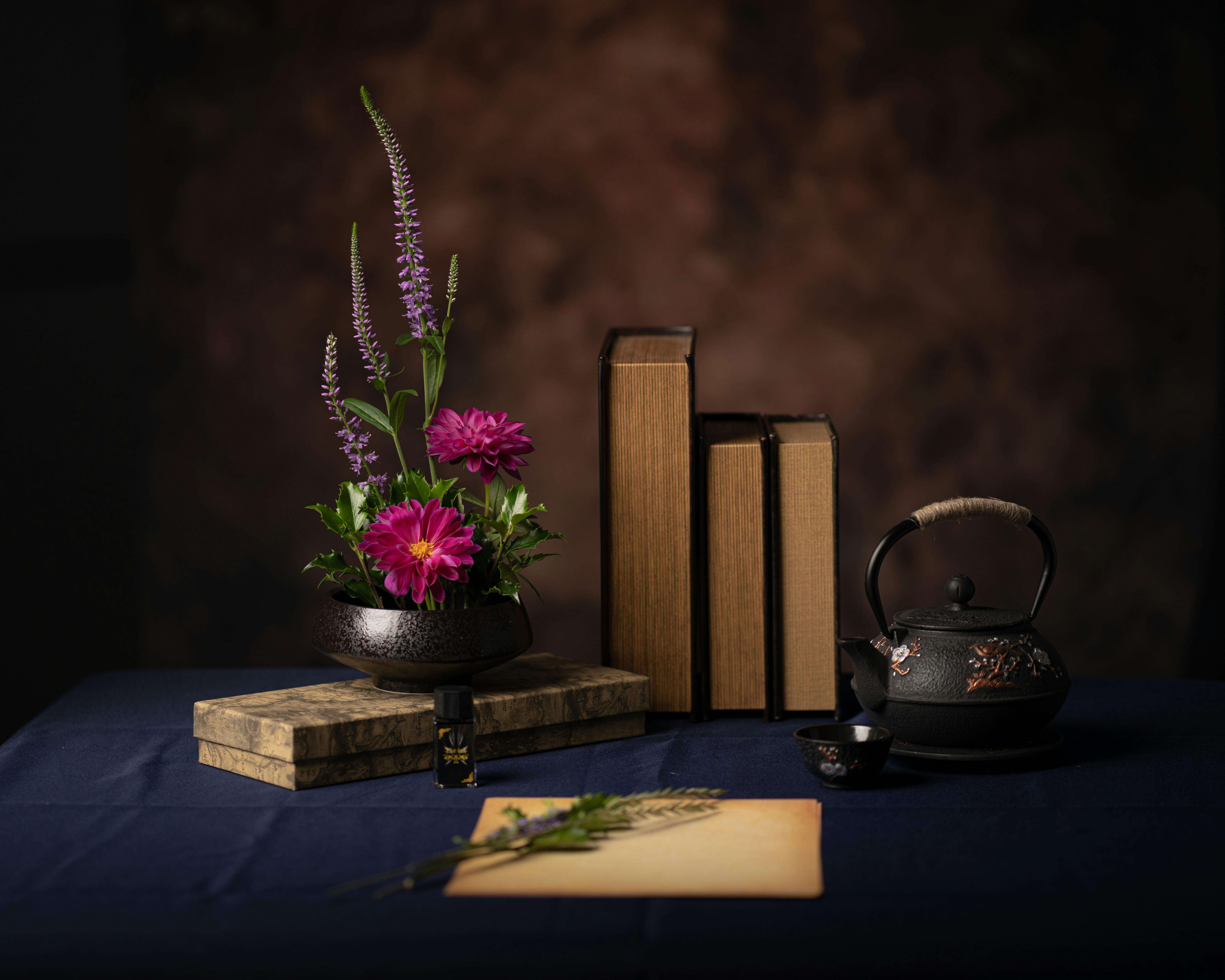 Flower Arrangement, Books, Kettle and Paper on Table · Free Stock Photo