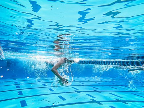Free Dynamic underwater shot of a swimmer in a pool showcasing technique and power. Stock Photo