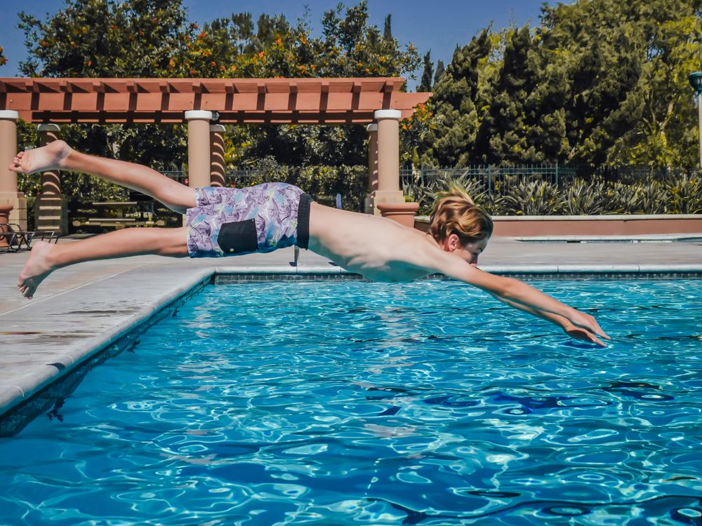 A Boy Jumping on a Swimming Pool · Free Stock Photo