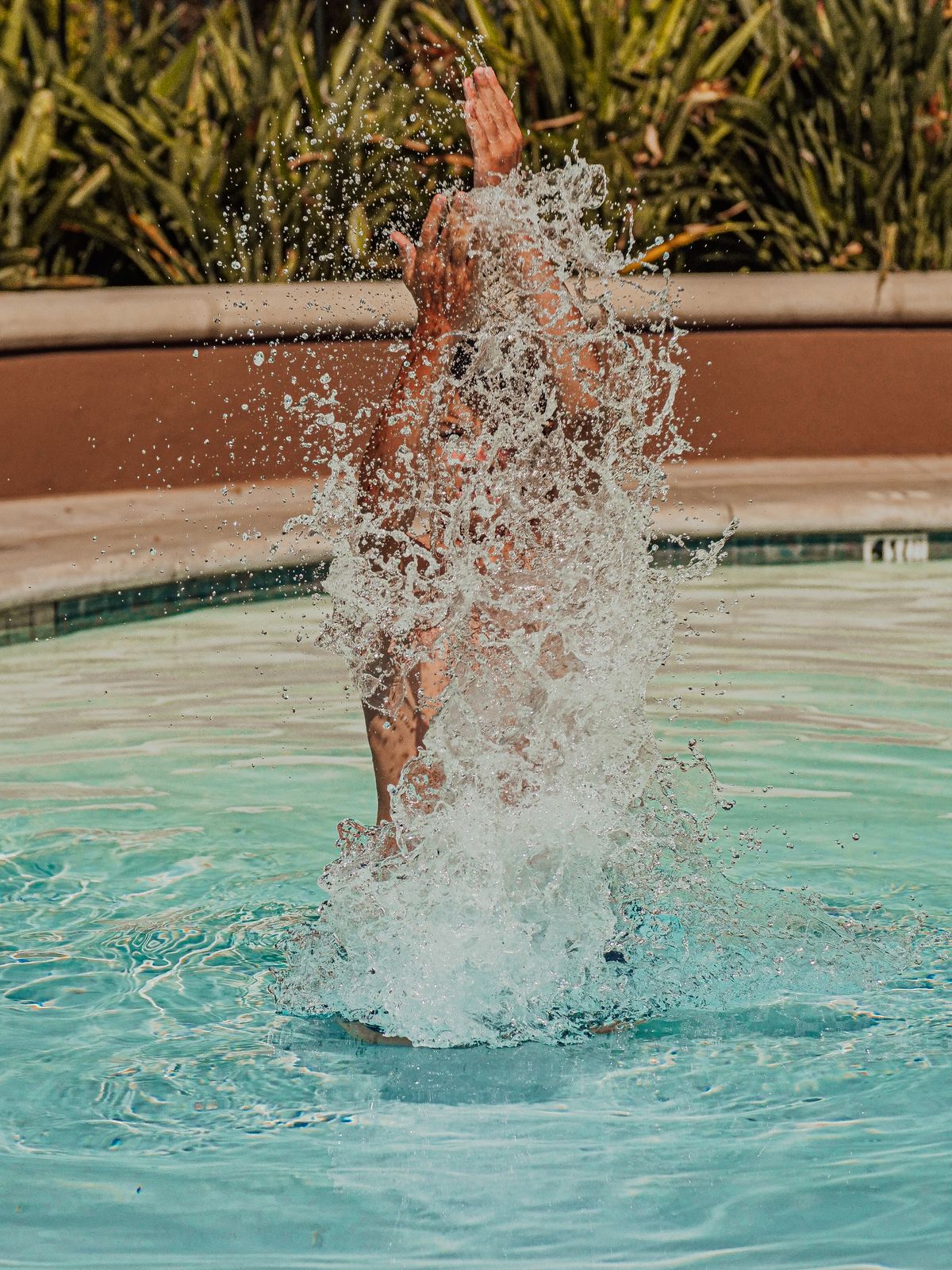 Child splashing water in a pool during pool party games