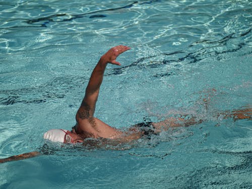 A Tattooed Man Swimming in the Pool 