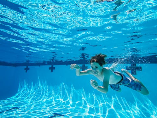 Photograph of a Boy Swimming Underwater