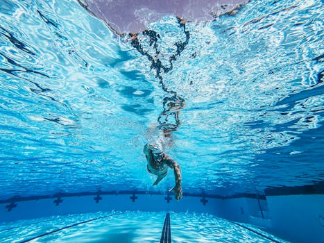 Dynamic underwater view of a swimmer practicing freestyle in a clear pool.