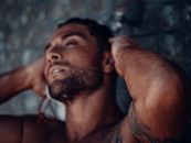 Topless Man With Red and White Earbuds