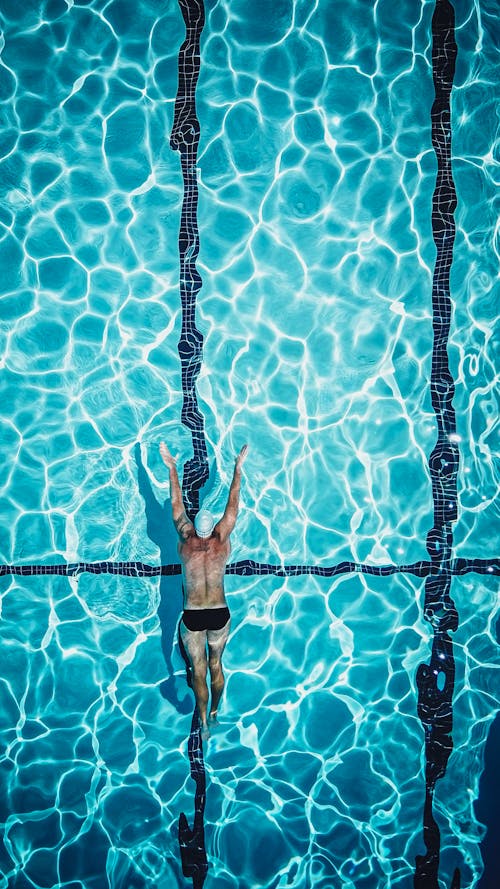 Drone Shot of a Person Swimming in a Pool
